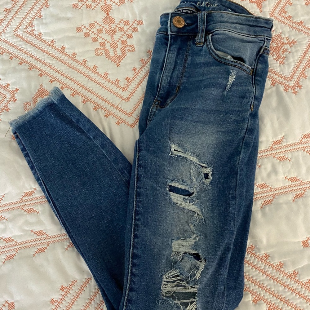 American Eagle distressed jeans with patch behind the above the knee parts